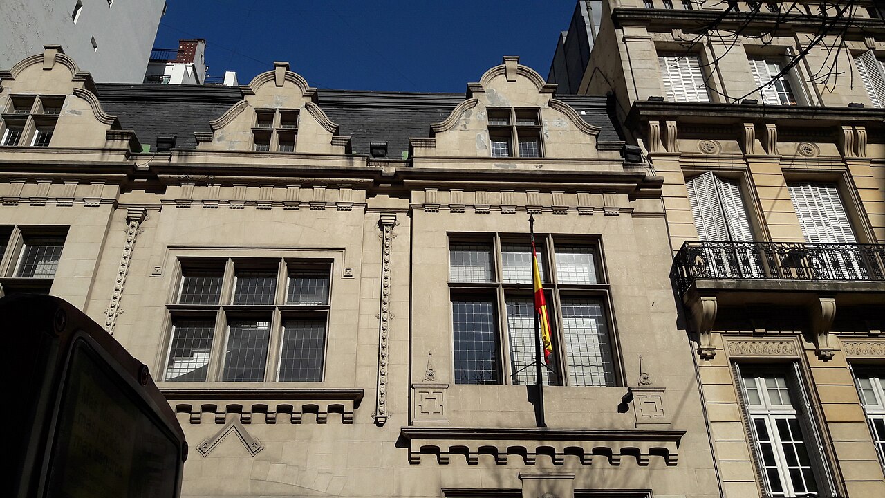 Fachada del Consulado General de España en Buenos Aires, edificio de piedra clara con una bandera de España en el balcón central