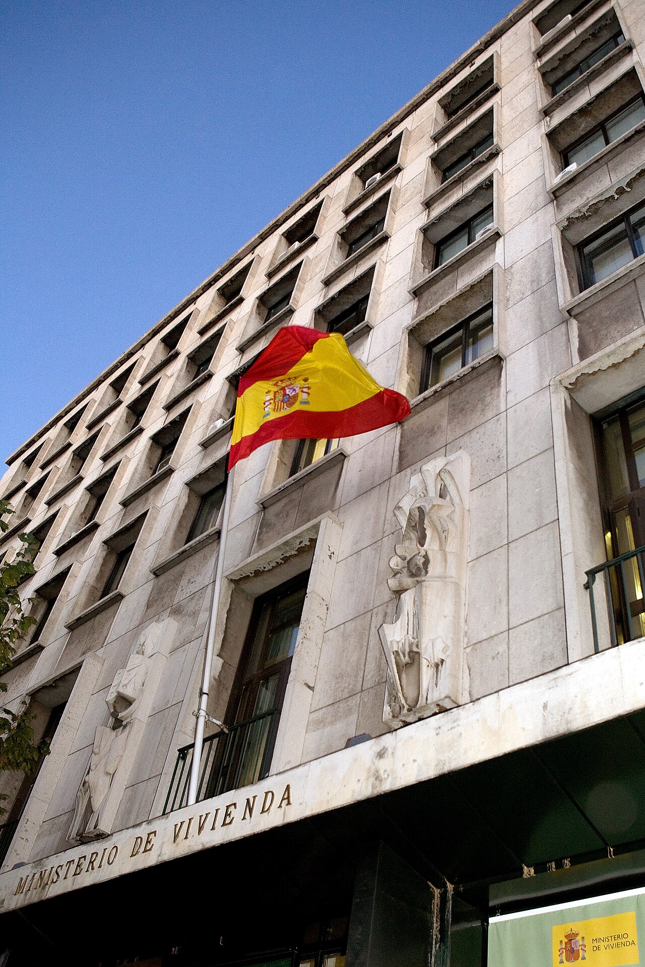 Fachada de la sede del Ministerio de Vivienda de España, un edificio administrativo de líneas verticales de hormigón y ventanas corridas, visto desde la calle