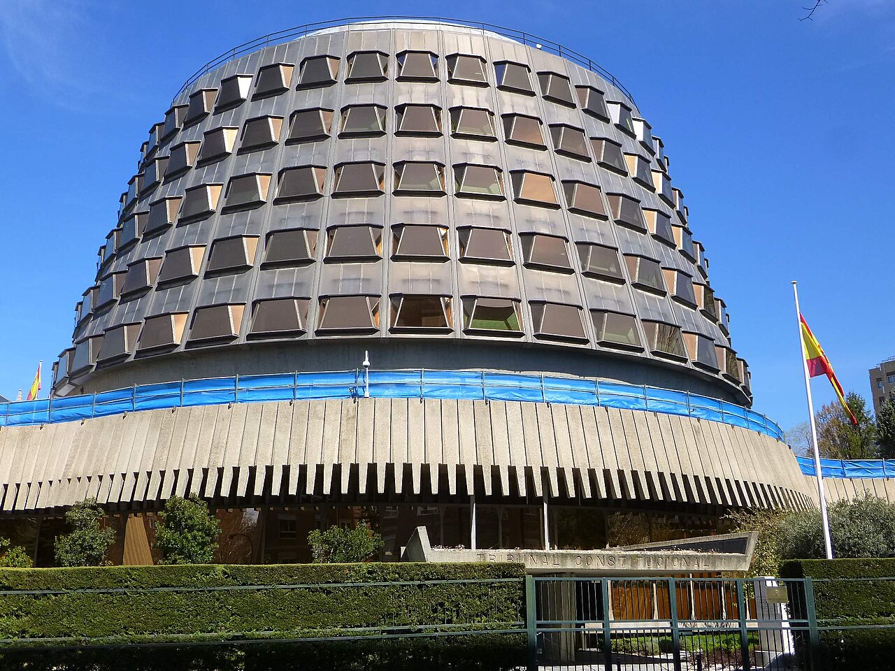 Edificio sede del Tribunal Constitucional en Madrid, con la bandera de España a la derecha